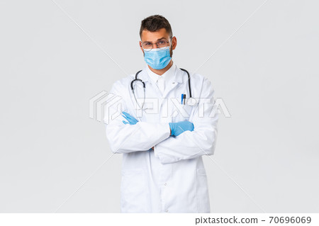 Covid-19, healthcare workers, pandemic and preventing virus concept. Doubtful and suspicious male doctor in scrubs and medical mask dont believe patient, raise eyebrow disbelief Covid-19, healthcare workers, pandemic and preventing virus concept. Doubtful and suspicious male doctor in scrubs and medical mask dont believe patient, raise eyebrow disbelief 70696069
