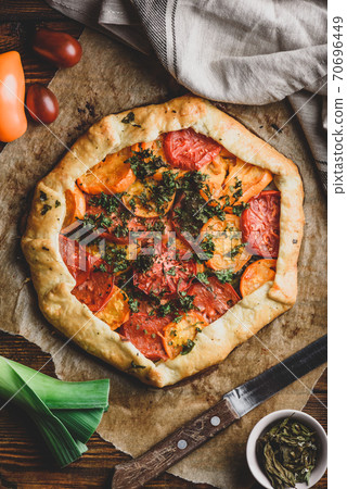 Baked tomato galette on baking paper Baked tomato galette on baking paper 70696449