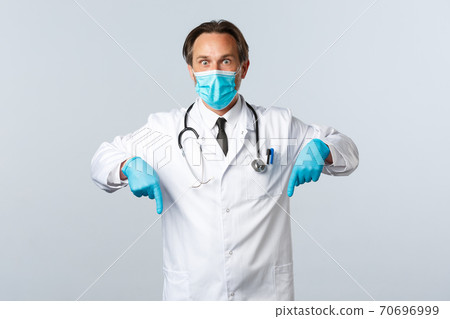 Covid-19, preventing virus, healthcare workers and vaccination concept. Shocked gasping male doctor in medical mask and cloves react to coronavirus outbreak percentage, pointing fingers down Covid-19, preventing virus, healthcare workers and vaccination concept. Shocked gasping male doctor in medical mask and cloves react to coronavirus outbreak percentage, pointing fingers down 70696999