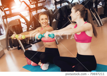 Girls look at each other and perform exercises. 70697211