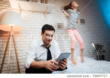 Little girl have fun while her dad is busy. 70697717