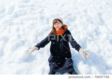 Girl sitting on the snow 70697786