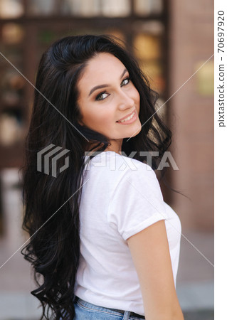 Portrait of beautiful young brunette woman in white t-shirt. Beautiful makeup 70697920