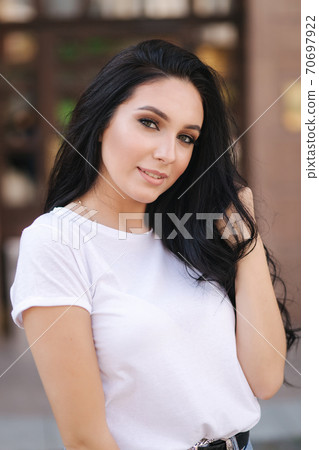 Portrait of beautiful young brunette woman in white t-shirt. Beautiful makeup Portrait of beautiful young brunette woman in white t-shirt. Beautiful makeup 70697922