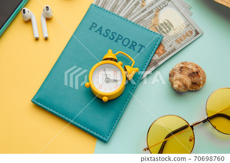 Tourism concept. Sunglasses, smartphone and passport with money banknotes on blue yellow background. Close-up 70698760
