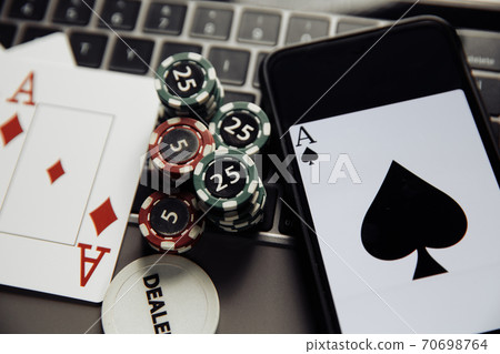 Online poker casino theme. Gambling chips, smartphone and playing cards on keyboard 70698764