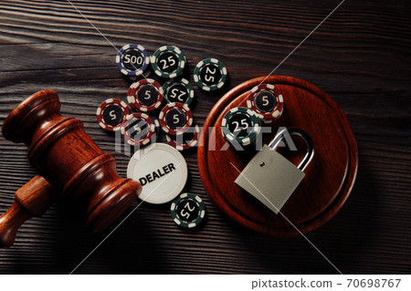 Gambling and law concept. Playing chips and judge gavel with padlock on wooden background Gambling and law concept. Playing chips and judge gavel with padlock on wooden background 70698767