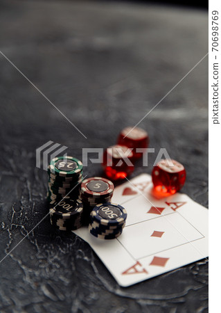 Chips, three red dices and playing cards with aces for poker online or casino gambling on table close-up. Online casino concept 70698769