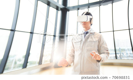 A man watching a video wearing VR goggles A man watching a video wearing VR goggles 70698831