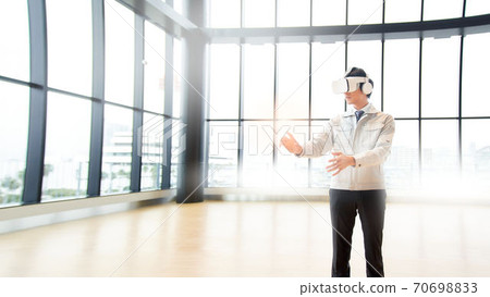 A man watching a video wearing VR goggles A man watching a video wearing VR goggles 70698833