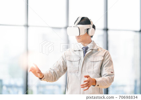 A man watching a video wearing VR goggles A man watching a video wearing VR goggles 70698834