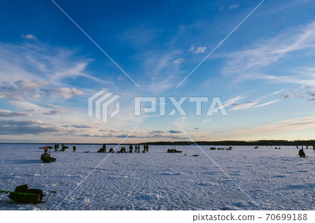group of fishermen fishing in winter on the ice of the river 70699188
