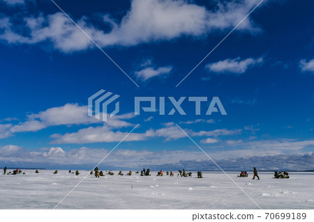 fishermen catch fish in winter on the ice on a day 70699189