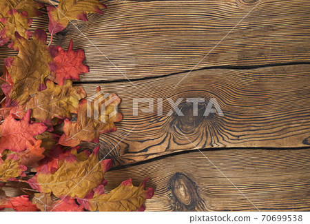 Colorful autumn leaves on a brown wooden background. Colorful autumn leaves on a brown wooden background. 70699538