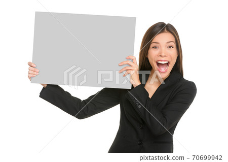 White sign happy Asian business woman holding blank card isolated on white background in studio portrait. Screaming excited Chinese businesswoman showing empty poster with copy space for text advert. 70699942