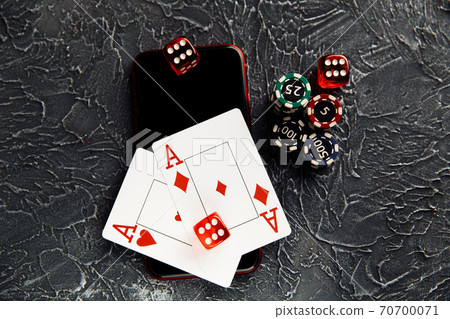 Casino play online concept. Playing chips, cards, three dices and smartphone 70700071