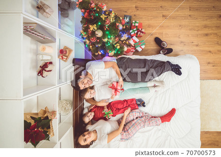 The happy parents giving gifts to kids near a christmas tree. view from above 70700573
