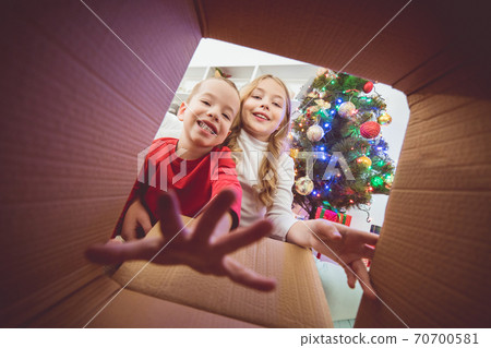 The happy children open the box near the christmas tree 70700581