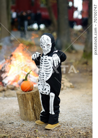 Little boy in scary skeleton costume at halloween celebrations party in forest.  70700747