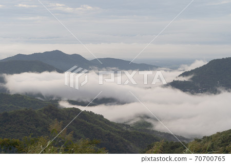 Aerial view of sunset above fluffy sea fog misty clouds with mountain hill from Phu Tub Berk, Khao Kho, Phetchabun with sunlight. Abstract nature landscape background at twilight time. Aerial view of sunset above fluffy sea fog misty clouds with mountain hill from Phu Tub Berk, Khao Kho, Phetchabun with sunlight. Abstract nature landscape background at twilight time. 70700765