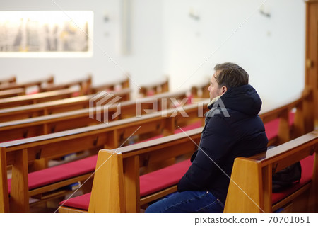 Religious middle age man praying in catholic church. Religious middle age man praying in catholic church. 70701051