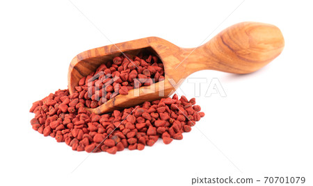 Annatto seeds in wooden scoop, isolated on white background. Achiote seeds, bixa orellana. Natural dye for cooking and food. Close-up. Annatto seeds in wooden scoop, isolated on white background. Achiote seeds, bixa orellana. Natural dye for cooking and food. Close-up. 70701079