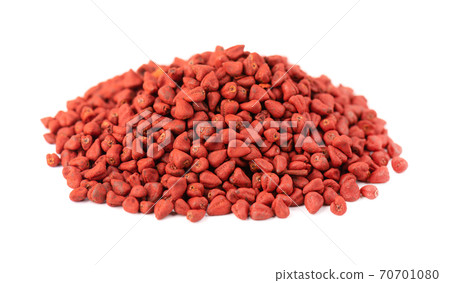 Annatto seeds, isolated on white background. Achiote seeds, bixa orellana. Natural dye for cooking and food. Close-up. 70701080