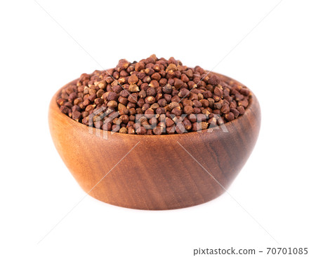 Guinea pepper grains in wooden bowl, isolated on white background. Melegeta, alligator pepper or mahlab. Grains of paradise. 70701085