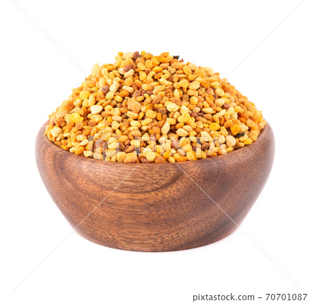Flower pollen grains in wooden bowl, isolated on white background. Pile of bee pollen or perga. 70701087