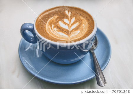 Ayurvedic coffee cappuccino cup in trendy american cafe. Milk foam in rosetta latte art 70701248
