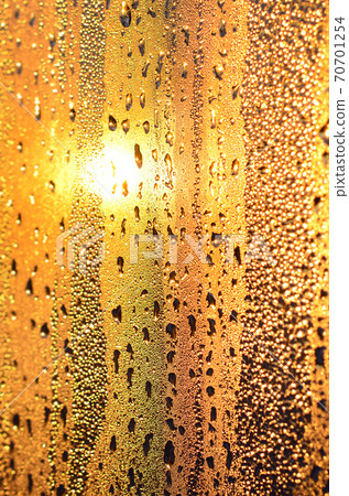 The texture of misted glass with a lot of drops and drips of condensation against the sunlight at dawn. Background image 70701254