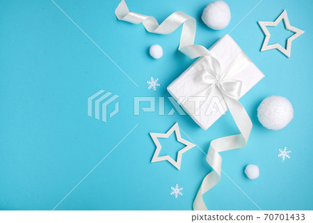 Christmas composition, gift box and white balls on blue background, minimalism. Christmas composition, gift box and white balls on blue background, minimalism. 70701433