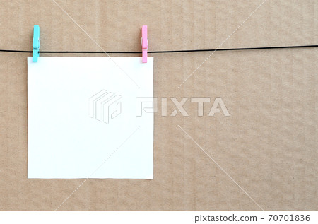 White blank card on rope on a brown cardboard background. Creative reminder, small sheet of paper on wooden clothespin, memo backdrop White blank card on rope on a brown cardboard background. Creative reminder, small sheet of paper on wooden clothespin, memo backdrop 70701836