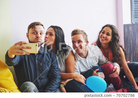 Group portrait of multi-ethnic boys and girls with colorful fashionable clothes holding friend and posing on a brick wall, Urban style people having fun, Concepts about youth and lifestyle 70702786
