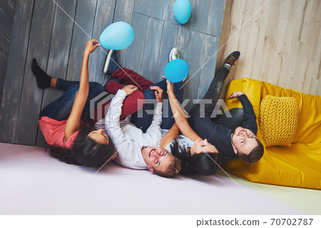Group portrait of multi-ethnic boys and girls with colorful fashionable clothes holding friend and posing on a brick wall, Urban style people having fun, Concepts about youth and lifestyle 70702787