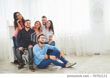 Group portrait of multi-ethnic boys and girls with colorful fashionable clothes holding friend and posing on a brick wall, Urban style people having fun, Concepts about youth and lifestyle Group portrait of multi-ethnic boys and girls with colorful fashionable clothes holding friend and posing on a brick wall, Urban style people having fun, Concepts about youth and lifestyle 70703131
