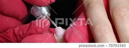 Manicure master processes cuticles in the salon Manicure master processes cuticles in the salon 70703565