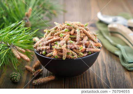 Bowl of pine buds. Pine tree buds and twigs with needle on table. Bowl of pine buds. Pine tree buds and twigs with needle on table. 70704055