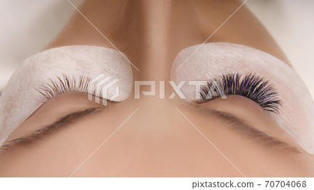 Eyelash Extension Procedure. Close up view of beautiful female eye with long eyelashes, smooth healthy skin. Eyelash Extension Procedure. Close up view of beautiful female eye with long eyelashes, smooth healthy skin. 70704068