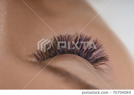 Eyelash Extension Procedure. Close up view of beautiful female eye with long eyelashes, smooth healthy skin. 70704069