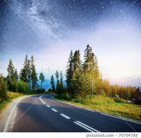 Asphalt road under a starry night sky and the Milky Way Asphalt road under a starry night sky and the Milky Way 70704788