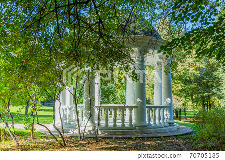 White stone garden house in a summer park White stone garden house in a summer park 70705185