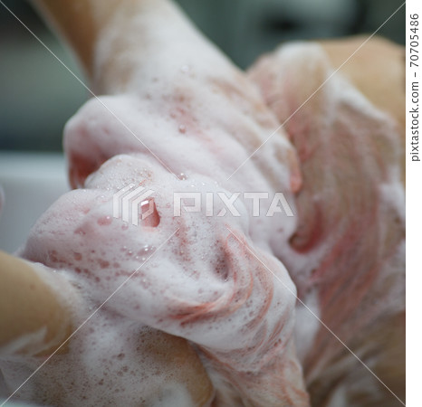 hairdresser's hands washing the client's pink hair with foam shampoo 70705486