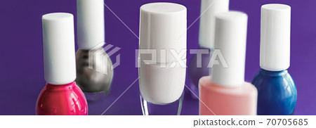 Nail polish bottles on dark purple background, beauty brand 70705685
