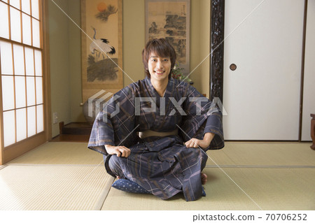 A man wearing a yukata with crossed legs 70706252