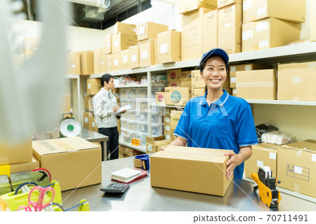 Young woman packing in a warehouse Young woman packing in a warehouse 70711491