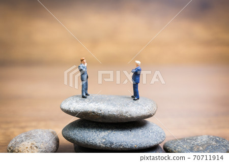Miniature people : Businessman standing on stone , Challenges and risks Concept 70711914