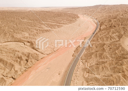 Dryness land with erosion terrain with highway crossing. 70712590