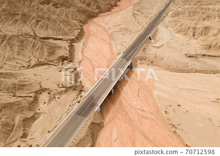 Dryness land with erosion terrain with highway crossing. Dryness land with erosion terrain with highway crossing. 70712598
