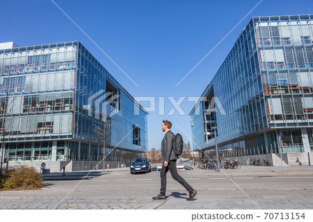 Young businessman commuter walking commuting to work going to office early morning on Copenhagen city street urban people commute lifestyle. Handsome man wearing suit in fall or spring Young businessman commuter walking commuting to work going to office early morning on Copenhagen city street urban people commute lifestyle. Handsome man wearing suit in fall or spring 70713154